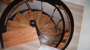Een wenteltrap met houten treden en metalen leuningen.
