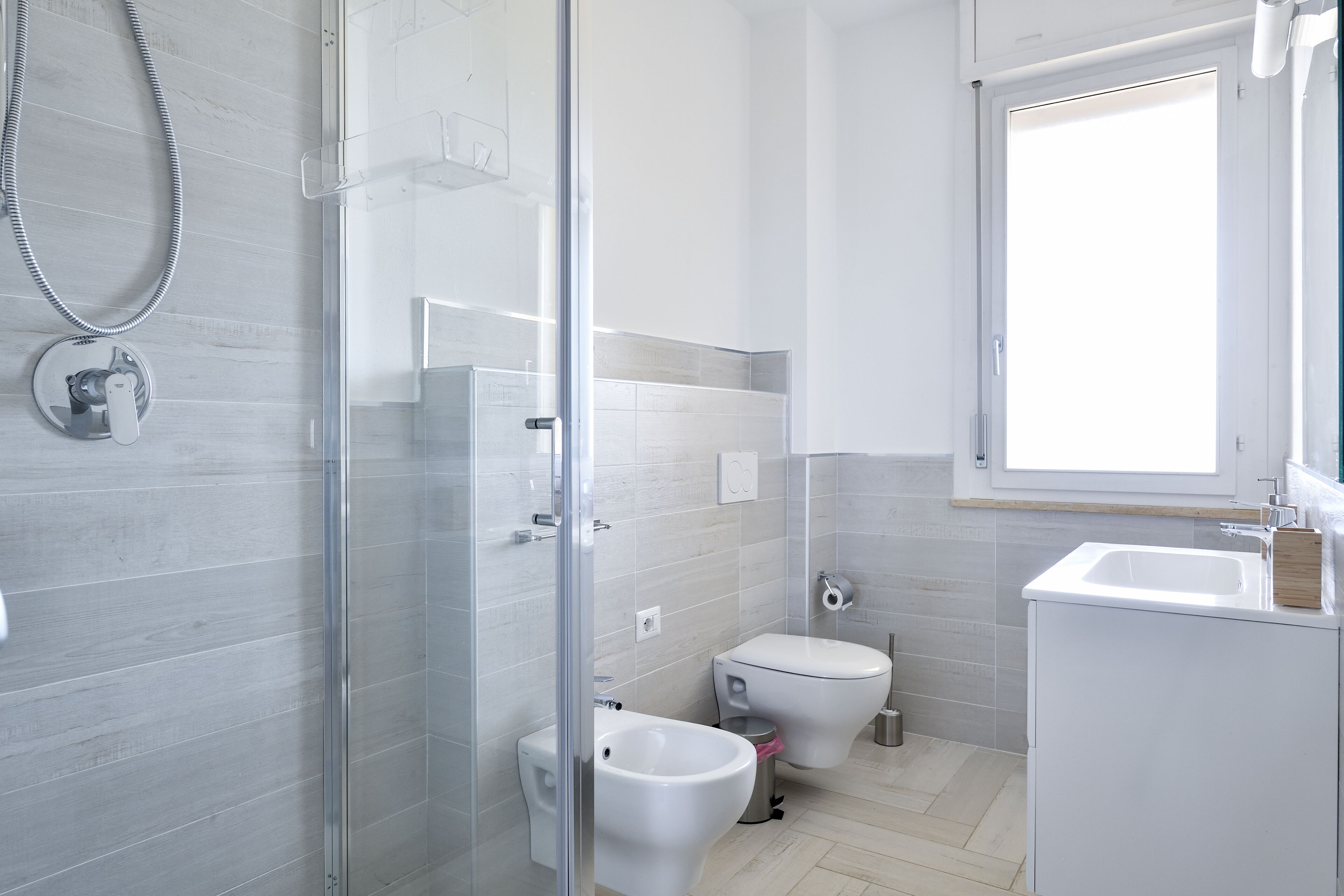 Une salle de bain moderne avec une douche à parois de verre, des toilettes et un lavabo.
