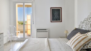 A bedroom with a bed, a chair, a nightstand, a lamp, and a framed picture on the wall. - Sea view five minutes from the beach IUN Q5161 (Quartu Sant'Elena)