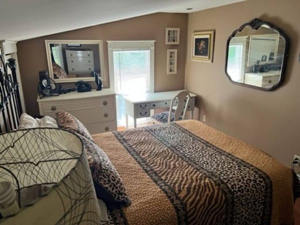 A bedroom with a bed, a dresser, a mirror, and a window. - A Bonnie Place 3.2 miles from All Star Village (Oneonta)