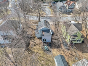 A residential area with houses, a driveway, and a small structure with a door and steps. - A Bonnie Place 3.2 miles from All Star Village (Oneonta)