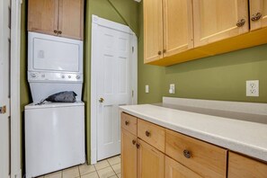 A compact kitchen with a washing machine, wooden cabinets, and a countertop. - A Bonnie Place 3.2 miles from All Star Village (Oneonta)