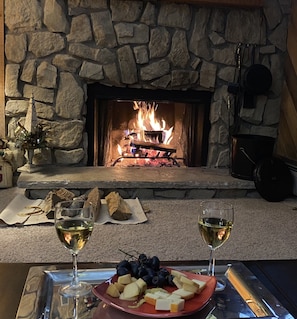 Enjoy a warm gathering by the fireplace with a table set for a relaxing evening.