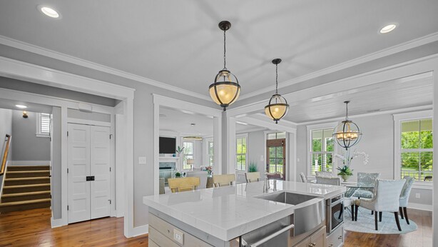 A spacious kitchen with a large island, stainless steel appliances, and pendant lighting.