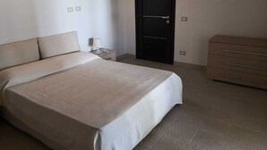 Una camera da letto con un letto, un comodino, una lampada e un armadio.