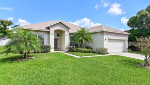 A single-story house with a front porch, a garage, and a well-maintained lawn. - Family Disney Paradise with Pool & Game Room  (Davenport)