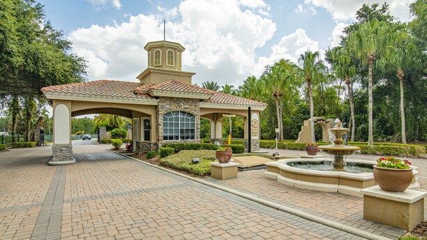 A building with a tiled roof, a stone facade, and a fountain in the courtyard. - Family Disney Paradise with Pool & Game Room  (Davenport)