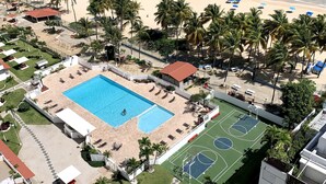 A resort with a swimming pool, tennis courts, and a beach with umbrellas. - This is a relaxing18th floor front beach apartment, with magnificent ocean view (Carolina)