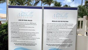 A signboard with pool rules and regulations in English and Spanish. - This is a relaxing18th floor front beach apartment, with magnificent ocean view (Carolina)