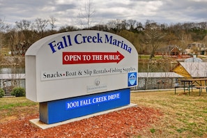 Une pancarte indique que la marina de Fall Creek est ouverte au public et propose des collations, la location de bateaux et d’emplacements de port, ainsi que du matériel de pêche.
