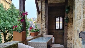 Een terras met rieten meubels en plantenpotten.