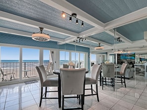 Enjoy meals at the large dining table surrounded by comfortable chairs, with a view of the ocean.
