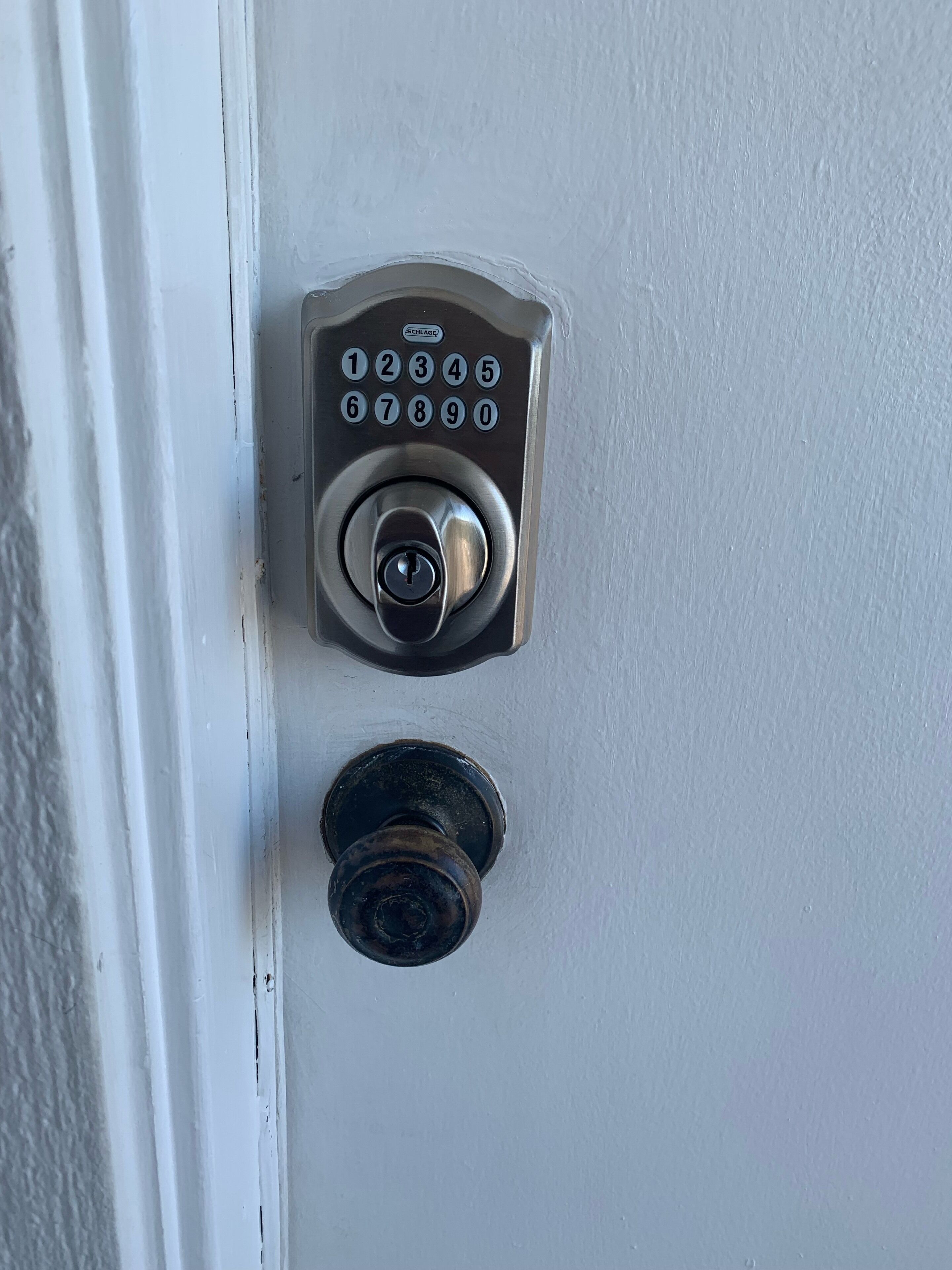 En dörr med ett numeriskt kodlås och ett nyckelhål.
