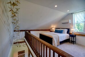 A bedroom with a bed, bedside table, and a window with curtains. - Historic charm, all new amenities at Swallow's Rest: East (West Grove)