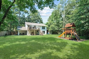 Enjoy a peaceful retreat with a balcony and deck overlooking a lush, well-maintained lawn and a play area for kids.