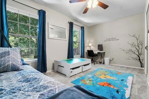Relax in a spacious bedroom with a large bed, desk, and world map rug.