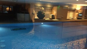 A hotel lobby with a reception desk, a large potted plant, and a patterned floor. - Luxury apartment in Whitbarrow Holiday Village near Pooley Bridge & Ullswater (Penrith)