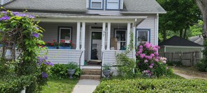 A two-story house with a porch, potted plants, and a wooden fence. - Casinos, beaches, and history (Norwich)