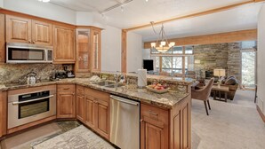 A modern kitchen with wooden cabinets, granite countertops, and stainless steel appliances. - Powder Run 12C 100 yards to Lift Unbeatable (Park City)