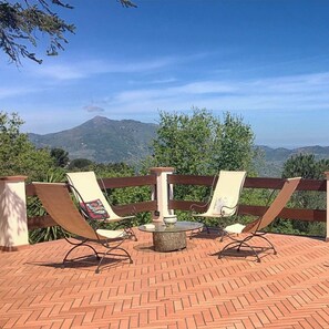 A terrace with two lounge chairs and a small table, overlooking a mountainous landscape. - Panoramic Villa Valù with private pool and breathtaking view (Castelbuono)