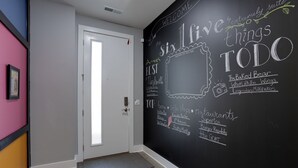 A hallway with a blackboard wall listing local attractions and businesses. - The Six1five by Extremely Suite★4 beds/4baths★9 BEDS★ROOFTOPDECK★HUGE SPACE (Nashville)