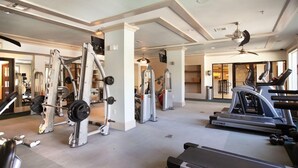 Une salle de sport équipée de divers appareils d’exercice, notamment des appareils de musculation et des appareils de cardio.