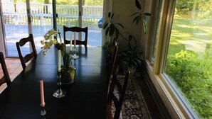 Une table à manger avec des chaises, un vase rempli de fleurs et des bougies.