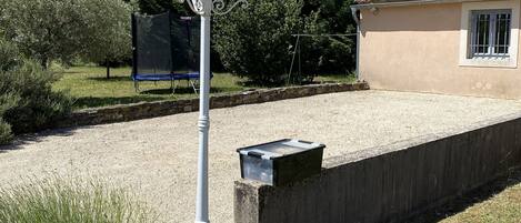 A house with a concrete wall, a lamp post, and a small window.