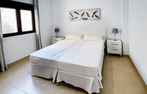 Cozy retreat with a large bed, bedside tables, and a wall-mounted artwork.