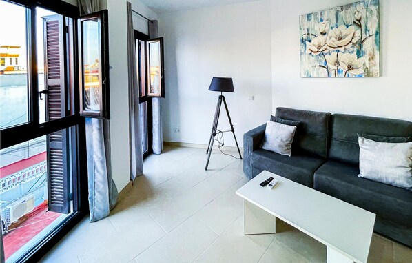 Relax in a clean and contemporary space with a sofa, coffee table, and floor lamp.