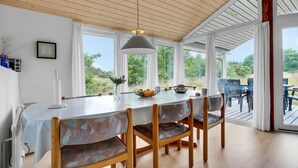 A dining area with a large table, chairs, and a view of greenery outside. - 3 bedroom lovely home in Fanø (Fanø)