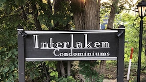 A sign for Interlaken Condominiums with a black background and white lettering.