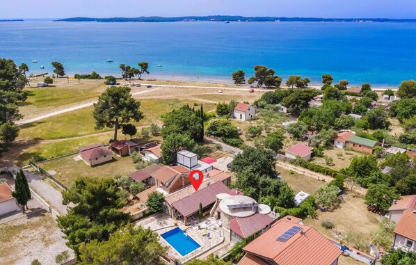 An aerial view of a coastal residential area with houses, a swimming pool, and a view of the sea. - Stunning home in Peroj (Peroj)