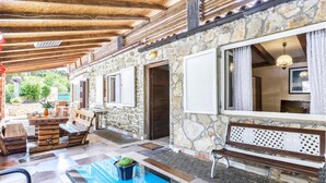 A stone building with a pool, wooden deck, and outdoor seating area. - Stunning home in Peroj (Peroj)