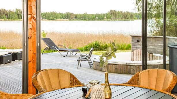 A deck with a table, chairs, and a view of a lake. - 5 bedroom beautiful home in Karlstad (Karlstad)