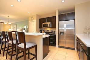 The spacious kitchen is fully-equipped and has breakfast bar seating as well!