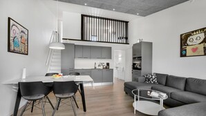 A modern apartment with a dining area, kitchen, living room, and a staircase leading to an upper level. - Gorgeous apartment in Ringkøbing (Ringkøbing)