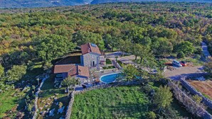 Una gran propiedad con un edificio de piedra, piscina y un jardín bien cuidado.