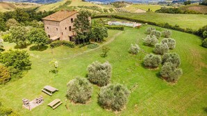 A stone building with a garden, a pool, and rolling hills in the background. - Nice home in Montaione (Montaione)