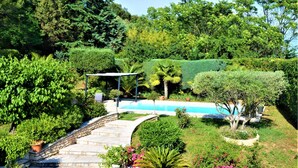 Ein angelegter Garten mit Schwimmbad, Steinstufen und verschiedenen Pflanzen.