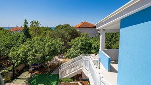 A blue building with a white staircase leading to a balcony. - Amazing apartment in Kosljun with WiFi (Kosljun)