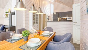 Eine moderne Küche mit weißen Schränken, einer eingebauten Mikrowelle und einem Essbereich mit einem Holztisch, gedeckt für vier Personen.