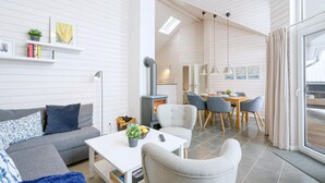 Ein modernes Wohnzimmer mit einer Couch, einem Couchtisch und einem Essbereich mit Stühlen und einem Tisch.