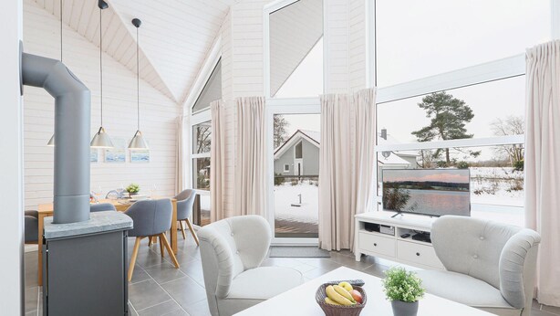 Ein modernes Interieur mit Essbereich, Sitzgelegenheiten und Blick ins Freie.