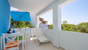 A balcony with white chairs, a table, and an umbrella. - 1 bedroom lovely apartment in Kosljun (Kosljun)