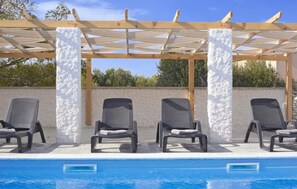 A poolside area with three lounge chairs under a pergola with white pillars. - Beautiful home in Lun (Lun)