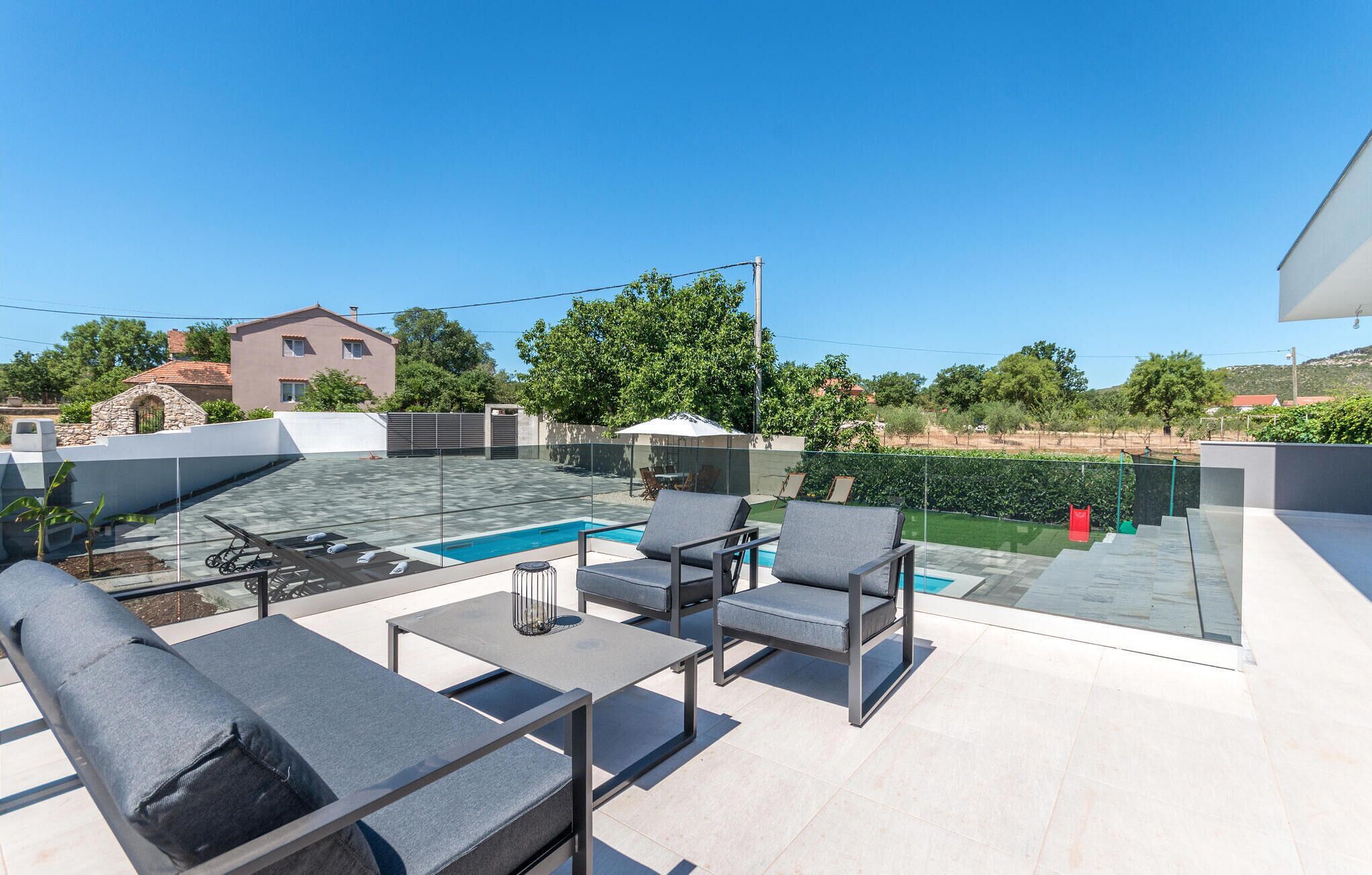 Terrassa al terrat amb piscina, mobiliari exterior i vista als edificis circumdants.