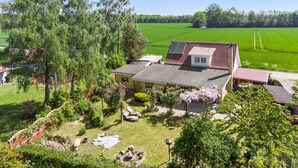 A house with a sloped roof, a small attached garage, and a well-maintained garden with a fire pit. - 2 bedroom nice home in Harpelunde (Harpelunde)