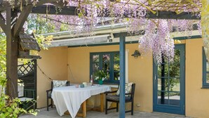A covered patio with a table and chairs, a door, and a window. - 2 bedroom nice home in Harpelunde (Harpelunde)