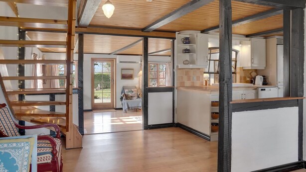 A spacious room with a wooden floor, a built-in bench, and a view of the outdoors. - 2 bedroom nice home in Harpelunde (Harpelunde)